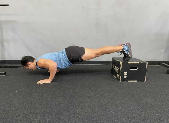 entraîneur faisant des pompes surélevées avec les pieds, faisant partie de l'entraînement pour brûler la graisse du ventre