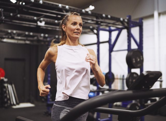 femme mature de remise en forme qui court sur un tapis roulant à la salle de sport