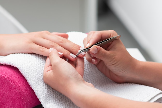 Femme faisant les ongles d'un client en gros plan