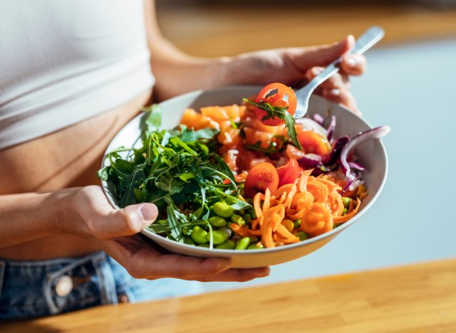 femme mangeant des légumes grande salade de glucides en bonne santé